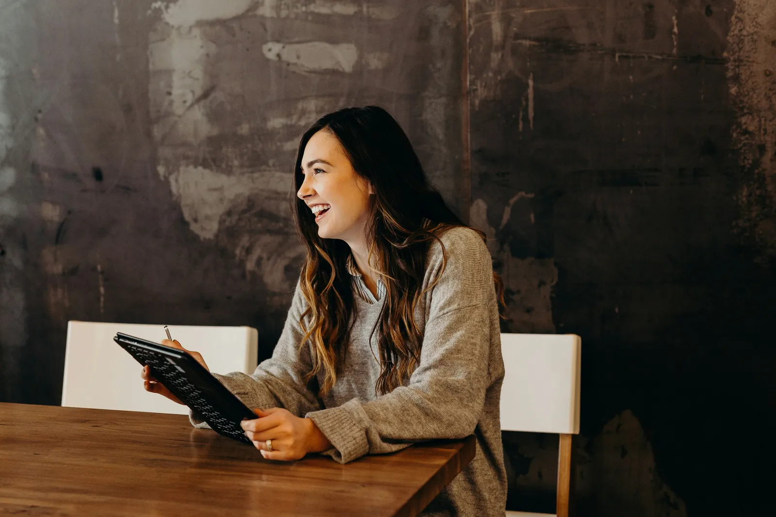Travailleuse indépendante assise à un bureau qui sourit