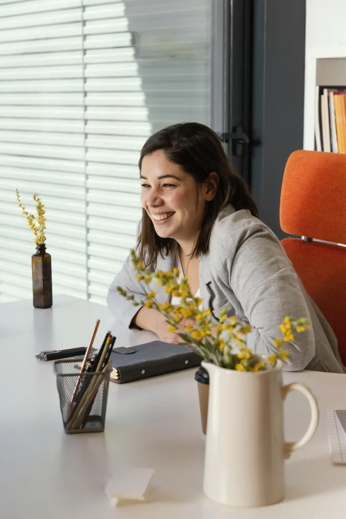 Freelance assise à un bureau qui sourit